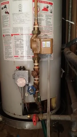 Installed water heater with copper piping, pressure relief valve, and drain valve connections